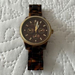 Beautiful brown tortious Michal Kors watch with crystals on face and gold trim.